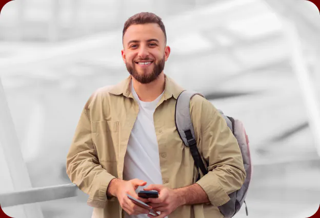 Estudante sorrindo com o celular na mão